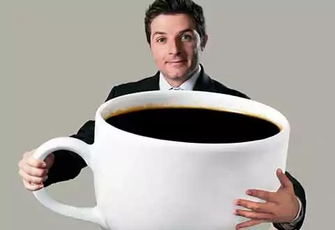 hombre sujeta taza gigante de cafe